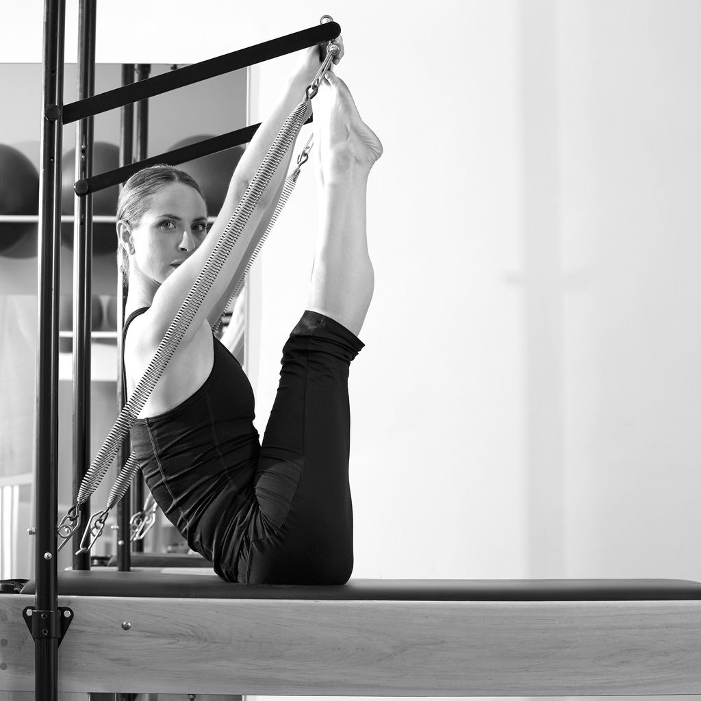 Pilates woman in reformer monki exercise at gym indoor